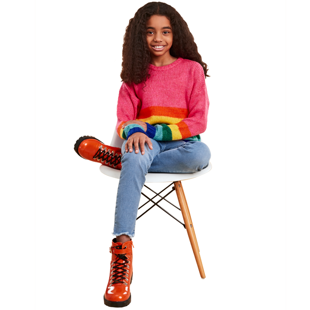 Young female sitting in chair wearing a colorful sweater