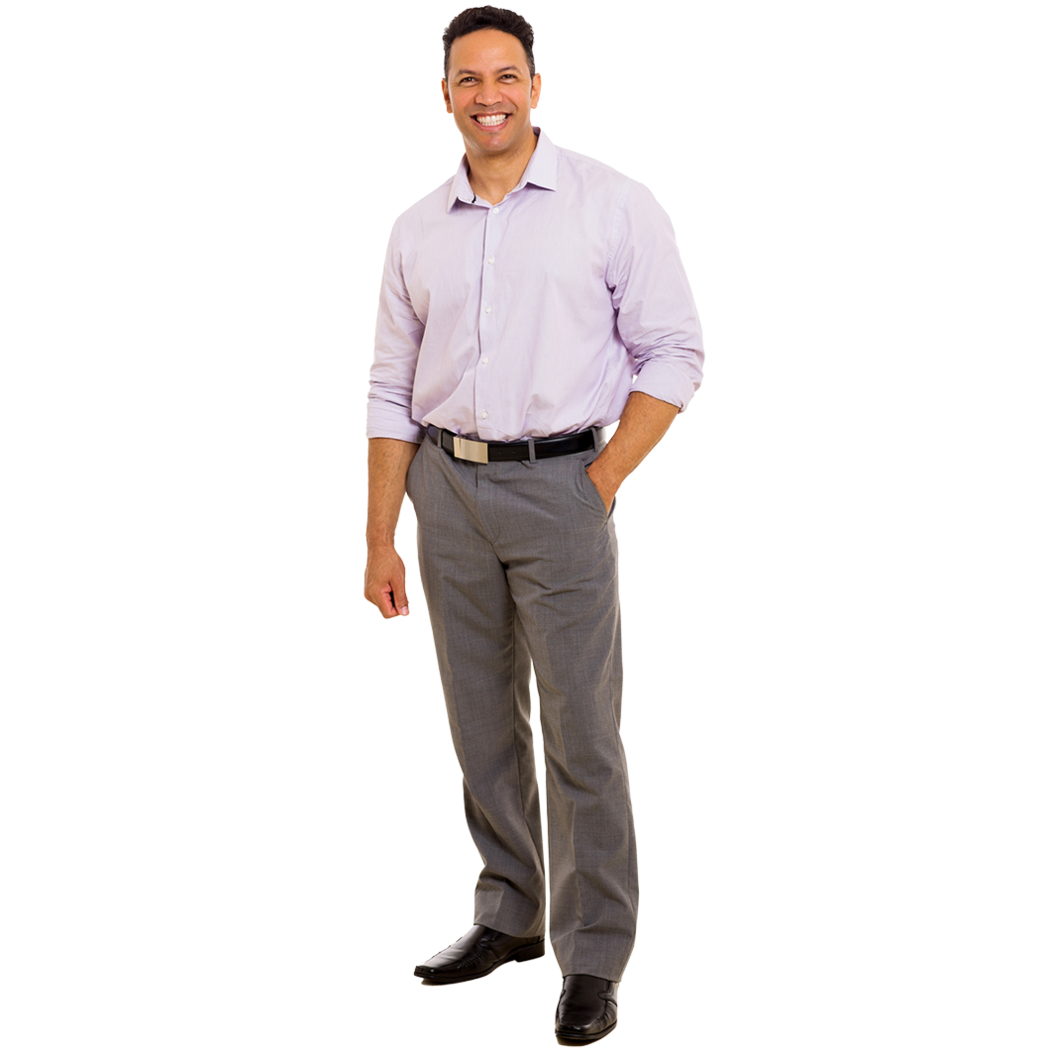 A male professional standing and smiling with one hand placed in his pocket