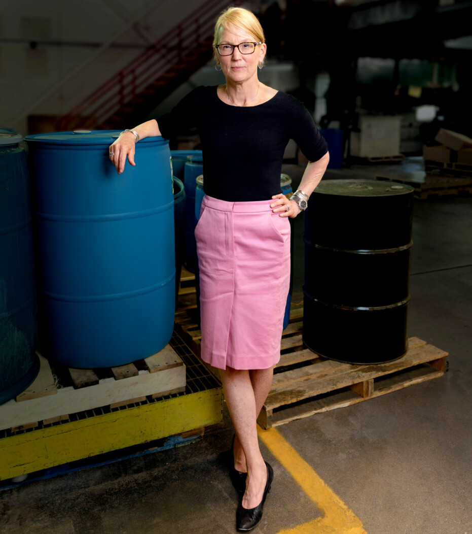 Hubbard Hall CEO Molly Kellogg of Waterbury CT standing and leaning against industrial barrel with hand on hip