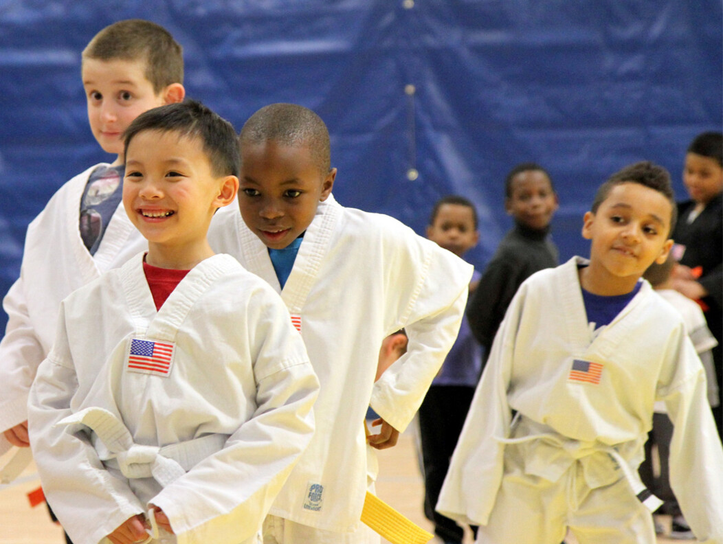 A group of young children in Waterbury CT wearing martial arts uniforms standing together