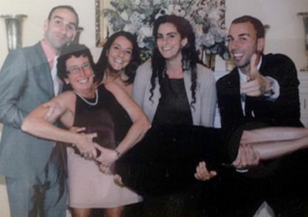 Cathy Awwad being lifted up by her four children for a family picture