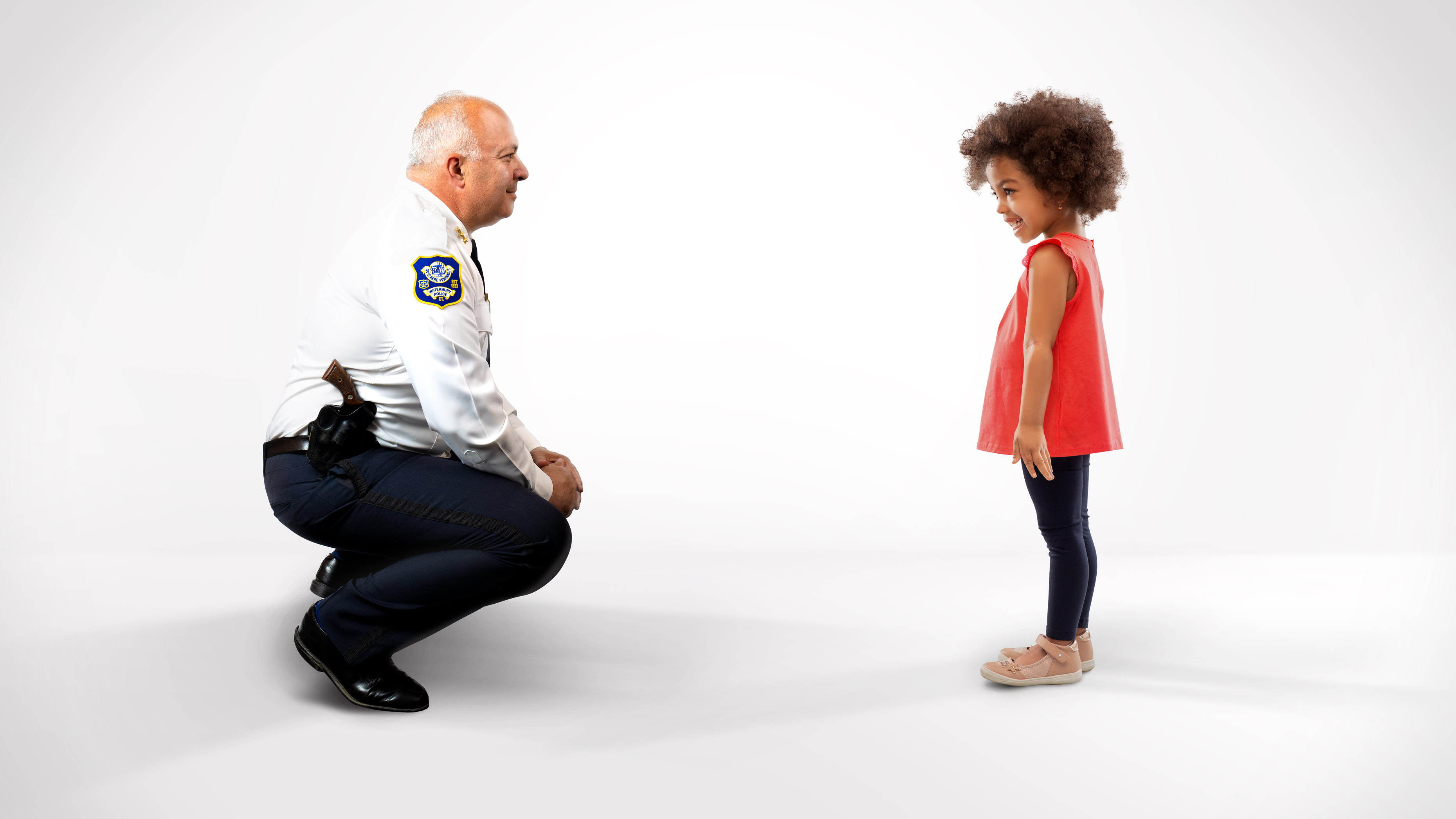 Waterbury, CT Chief of Police Fred Spagnolo kneeling down to speak with young girl